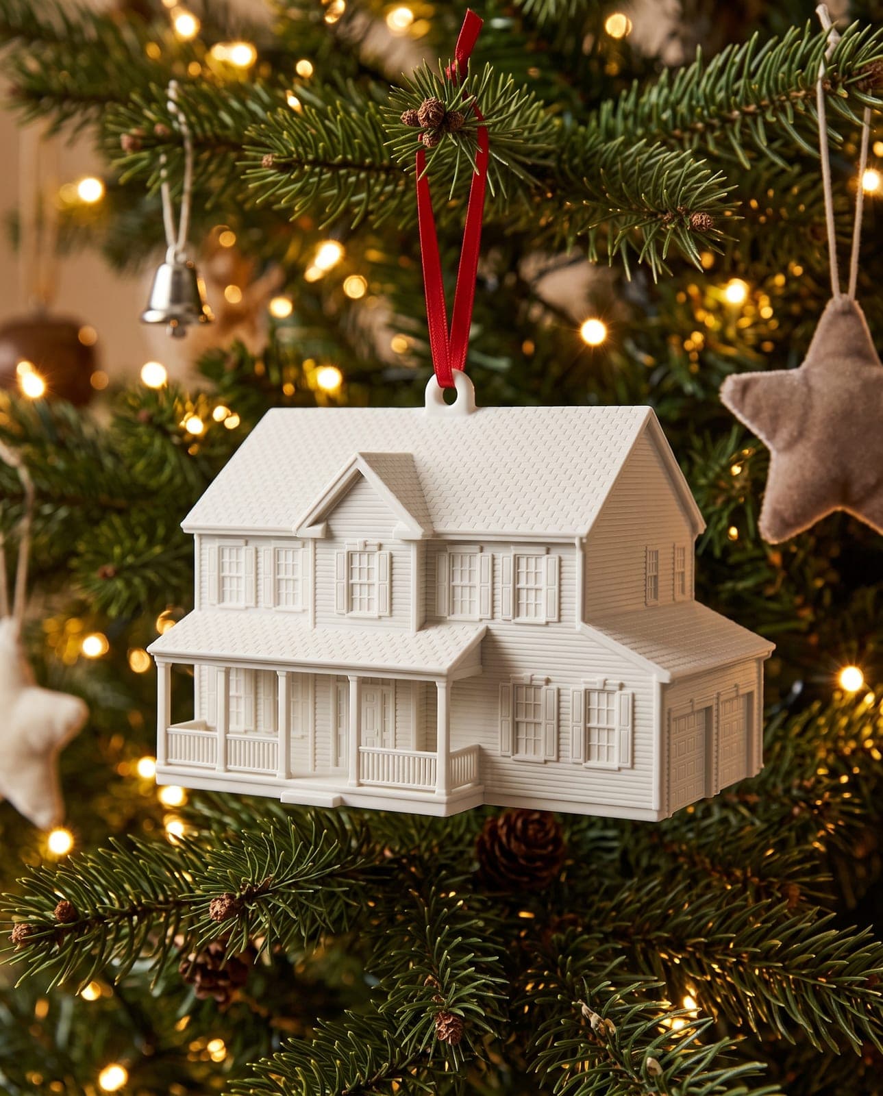 White House Ornament with a red ribbon hanging on a lit Christmas tree
