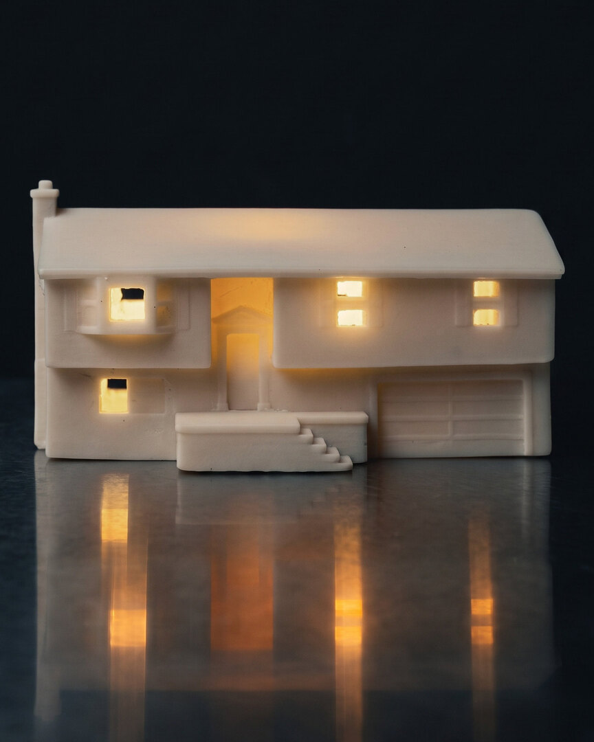 A real finished white split level house piece, glowing from inside on brushed steel