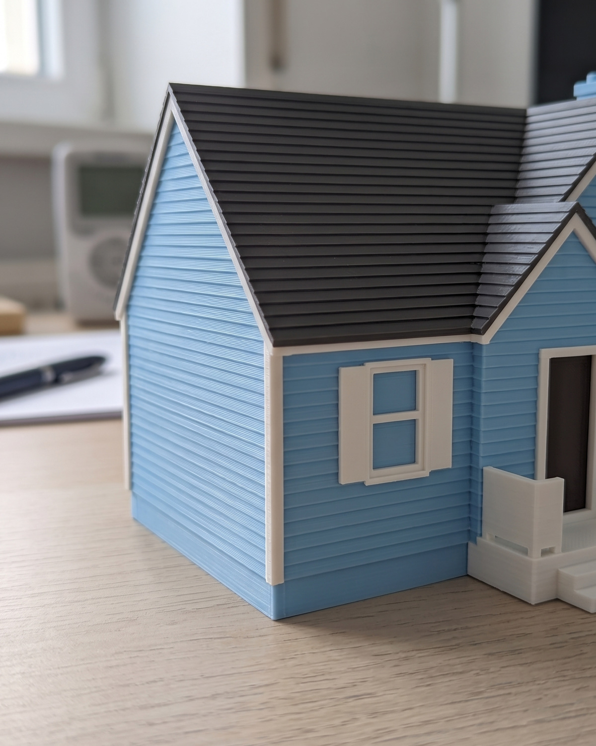A close view of a multicolor house keepsake showing the visible layer lines across its walls and roof, in a generated picture