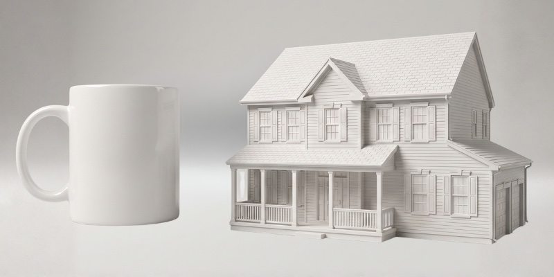 The large matte white house keepsake next to a coffee mug for scale
