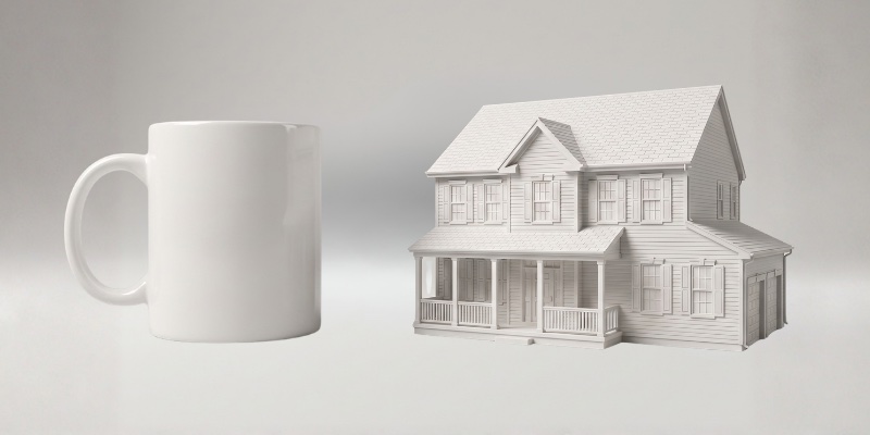 The medium matte white house keepsake next to a coffee mug for scale